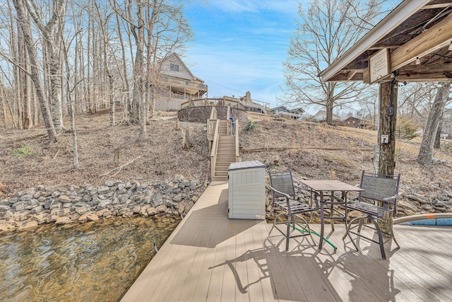 wooden terrace featuring stairs and outdoor dining area