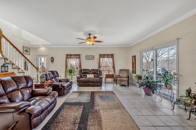 living area featuring baseboards, ceiling fan, stairs, ornamental molding, and light tile patterned floors