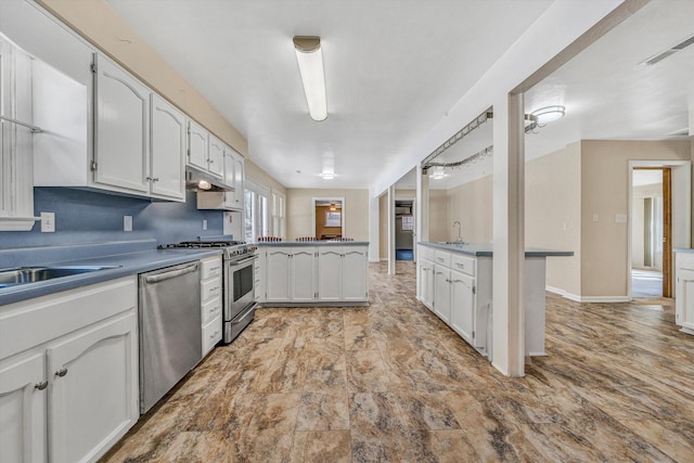 kitchen with visible vents, a peninsula, under cabinet range hood, appliances with stainless steel finishes, and white cabinetry