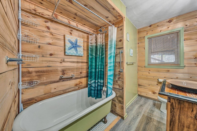 bathroom featuring wooden walls, wood finished floors, vanity, and toilet