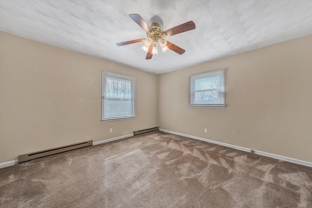 empty room featuring baseboard heating, a healthy amount of sunlight, and carpet flooring