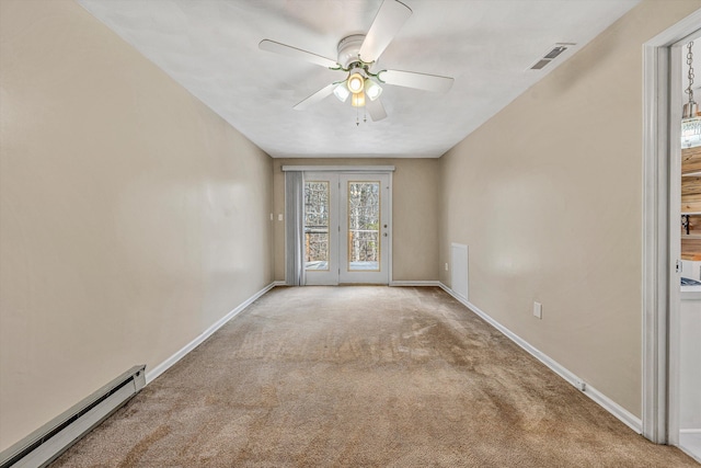 spare room featuring baseboards, a baseboard heating unit, carpet floors, and visible vents