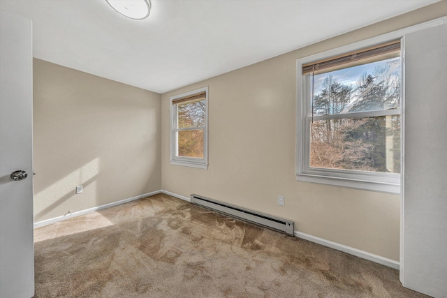 empty room with a baseboard heating unit, baseboards, and carpet floors