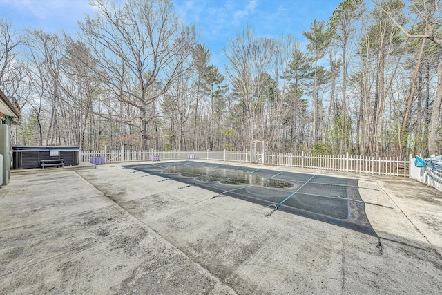 view of pool with a jacuzzi and fence