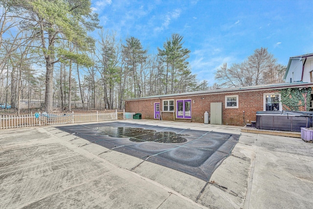 exterior space featuring fence and a hot tub