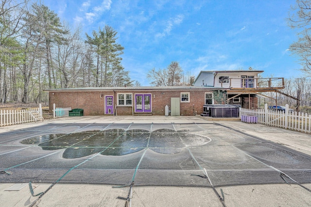 back of property featuring central air condition unit, fence, and brick siding