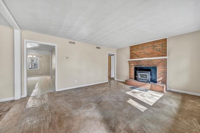 unfurnished living room with visible vents, baseboards, carpet, and a wood stove