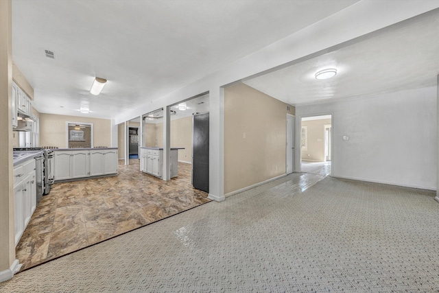 kitchen with visible vents, open floor plan, stainless steel appliances, white cabinets, and baseboards