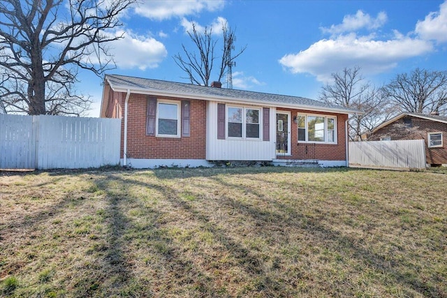 ranch-style home featuring brick siding, a chimney, a front yard, and fence