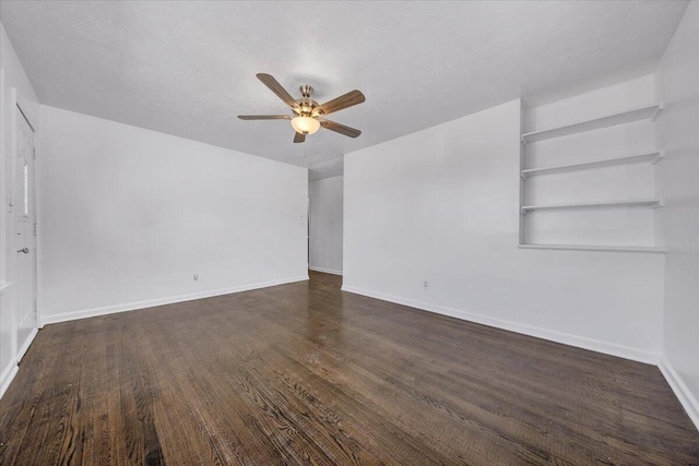 empty room with dark wood-style floors, ceiling fan, a textured ceiling, and baseboards