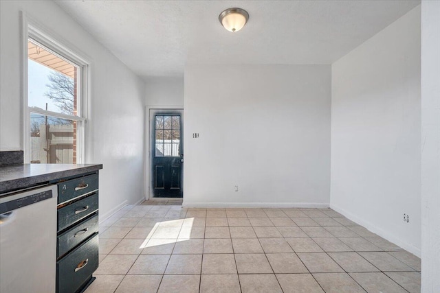 interior space with light tile patterned floors and baseboards