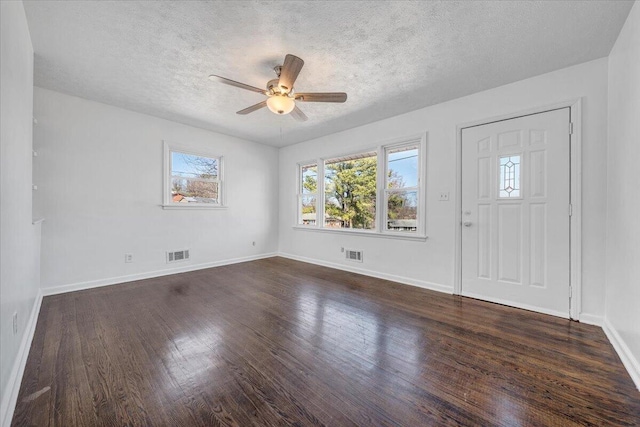 entryway with visible vents, a textured ceiling, dark wood-type flooring, and baseboards