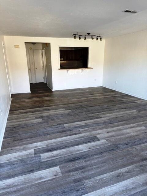 unfurnished room with dark wood-style floors and visible vents