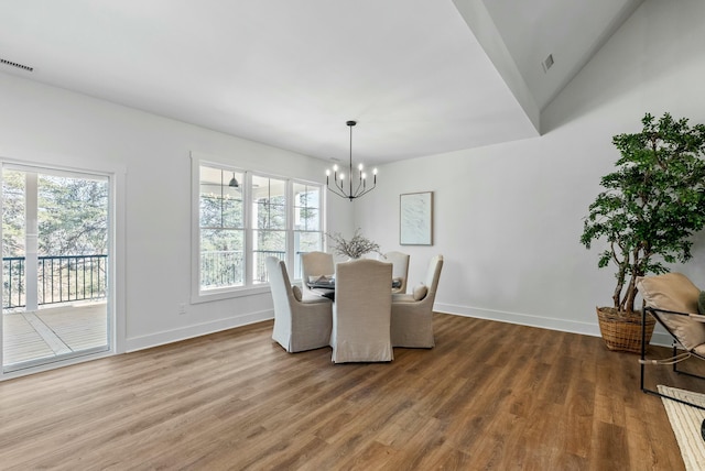 dining area with a notable chandelier, baseboards, and wood finished floors