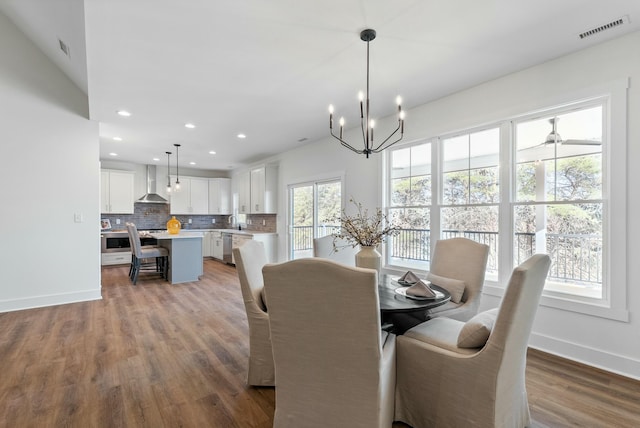 dining space featuring wood finished floors, visible vents, baseboards, recessed lighting, and a chandelier