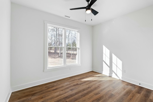 unfurnished room featuring ceiling fan, visible vents, baseboards, and wood finished floors