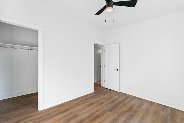 unfurnished bedroom with a closet, baseboards, wood finished floors, and a ceiling fan