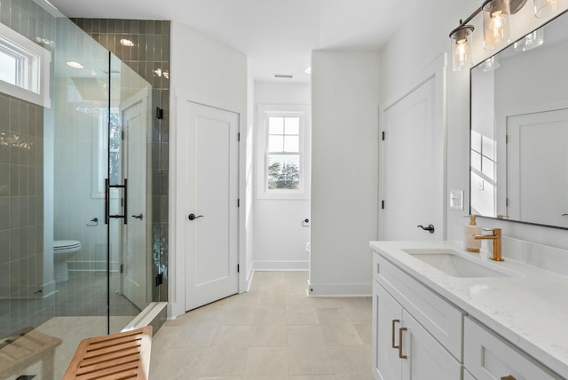 bathroom featuring vanity, toilet, a healthy amount of sunlight, and a stall shower