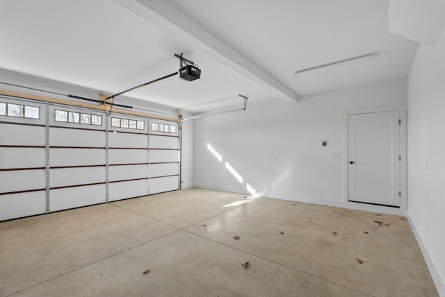 garage featuring a garage door opener and baseboards