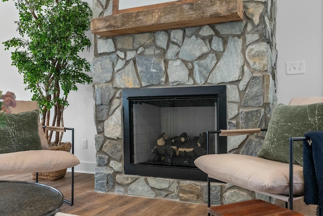 room details featuring a stone fireplace and wood finished floors