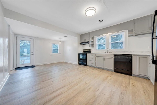 kitchen with visible vents, black appliances, gray cabinetry, under cabinet range hood, and light wood finished floors