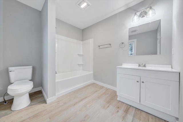 bathroom featuring vanity, wood finished floors, visible vents, baseboards, and toilet