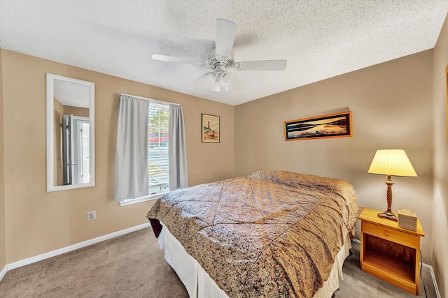 bedroom with a ceiling fan, baseboards, carpet floors, and a textured ceiling