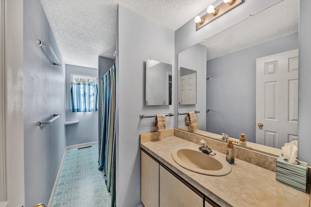 full bathroom with curtained shower, baseboards, a textured ceiling, and vanity