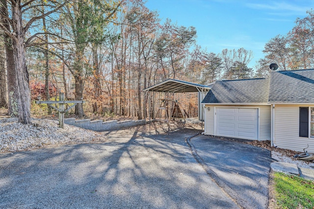 exterior space featuring aphalt driveway and a detached carport