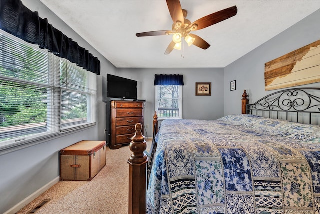 carpeted bedroom featuring baseboards, visible vents, and ceiling fan