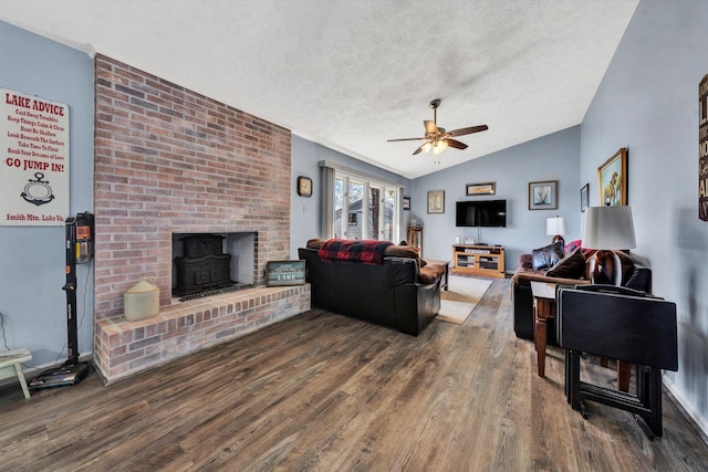 living room with ceiling fan, a textured ceiling, lofted ceiling, and wood finished floors