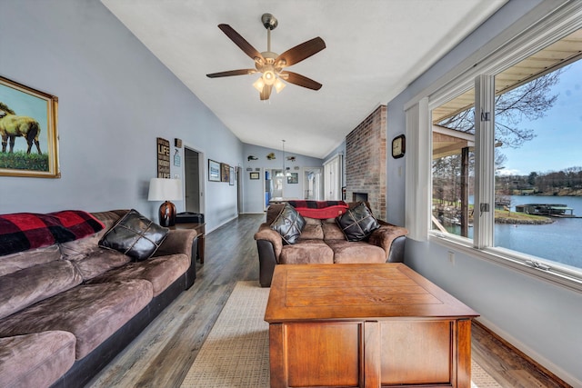 living area with lofted ceiling, wood finished floors, a ceiling fan, and a water view