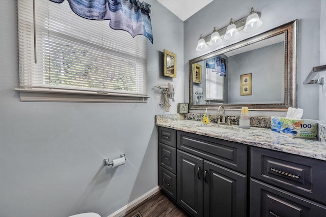 bathroom with vanity, baseboards, and wood finished floors