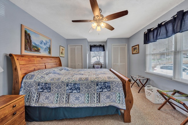 carpeted bedroom featuring two closets and a ceiling fan