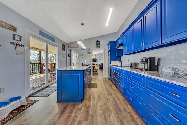 kitchen featuring dark wood finished floors, blue cabinetry, a center island, and vaulted ceiling