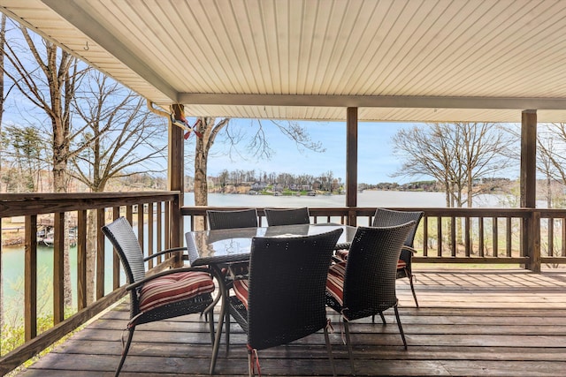 deck featuring outdoor dining area and a water view