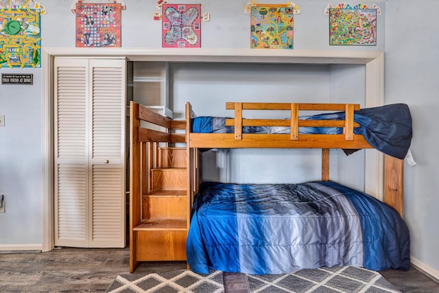 bedroom with a closet, baseboards, and wood finished floors