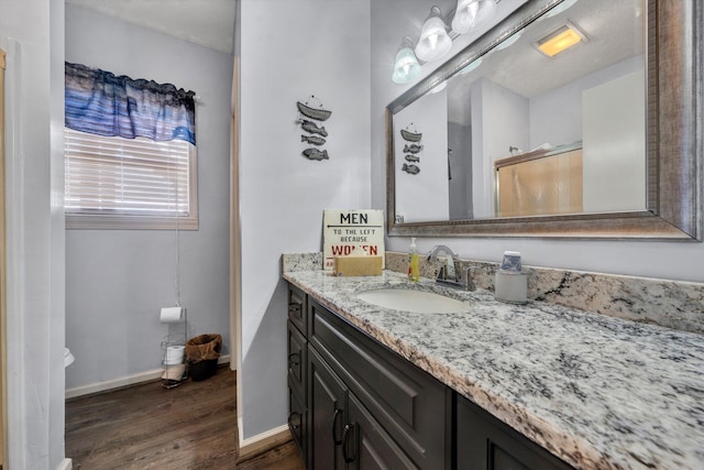 bathroom featuring vanity, baseboards, and wood finished floors