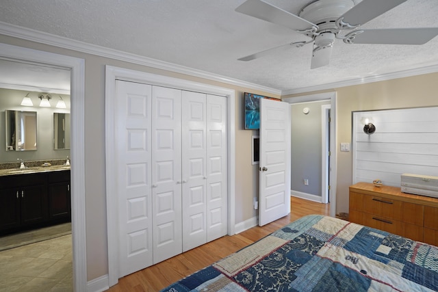 bedroom with light wood-style floors, ornamental molding, and a textured ceiling