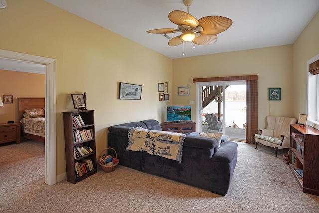 carpeted living area with ceiling fan