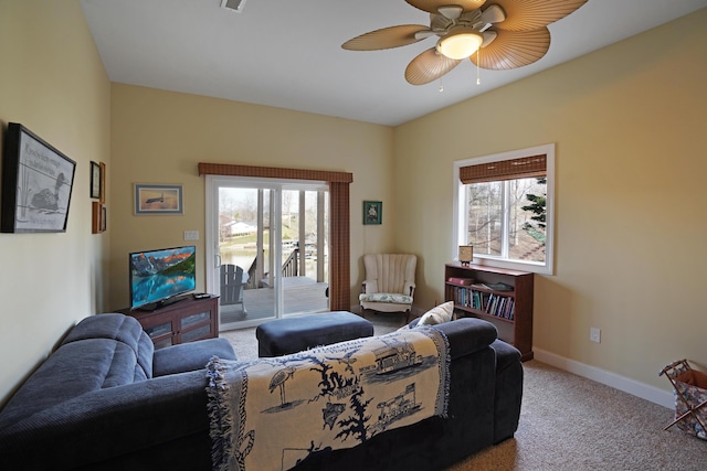 living area featuring plenty of natural light, baseboards, carpet floors, and ceiling fan