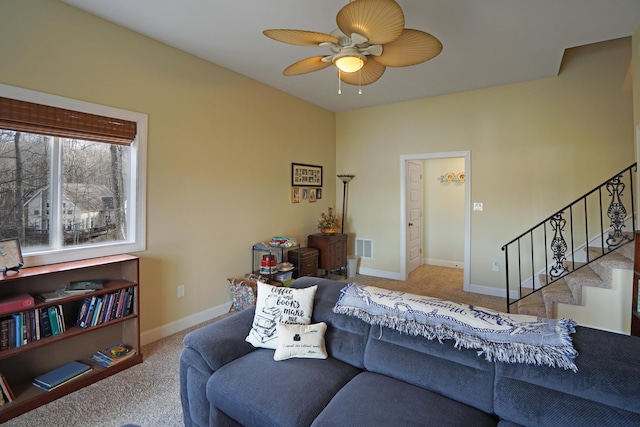 living room with a ceiling fan, visible vents, baseboards, stairs, and carpet flooring