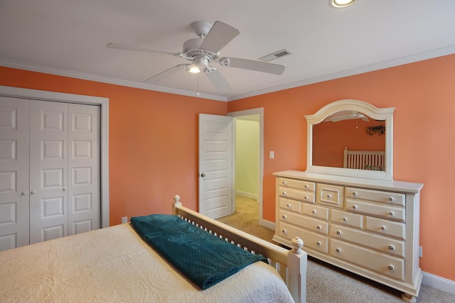 carpeted bedroom with visible vents, ornamental molding, a ceiling fan, a closet, and baseboards