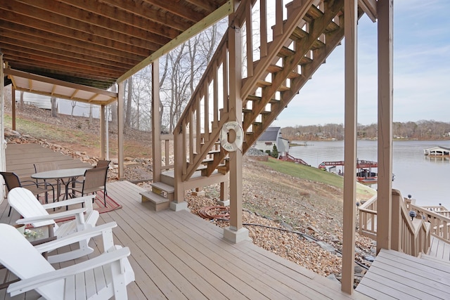 wooden deck featuring stairs and a water view