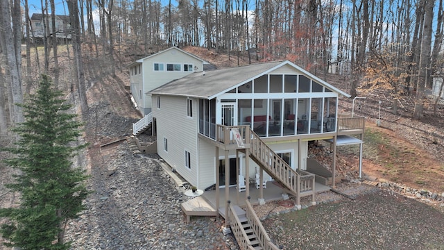 back of house featuring a wooden deck, stairs, and a sunroom