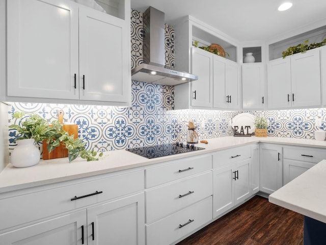 kitchen featuring backsplash, white cabinetry, wall chimney exhaust hood, light countertops, and black electric stovetop