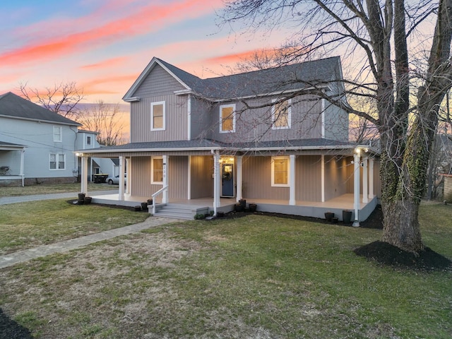 view of front facade with an attached carport, a porch, and a lawn