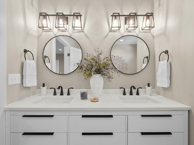 full bathroom with a sink and double vanity