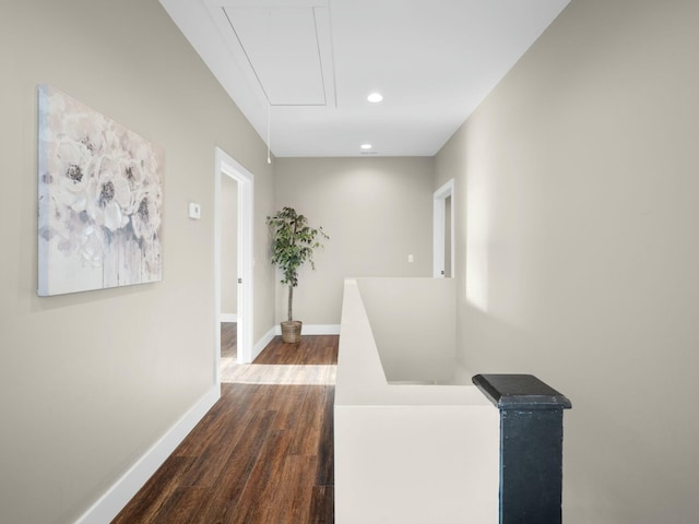 hallway featuring baseboards, attic access, recessed lighting, dark wood-type flooring, and an upstairs landing