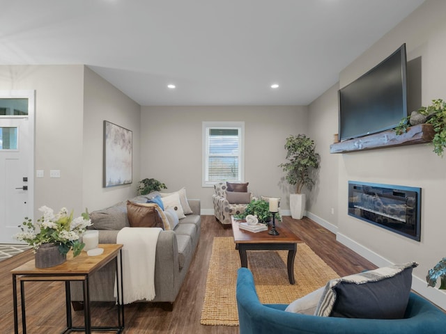 living room with a glass covered fireplace, recessed lighting, wood finished floors, and baseboards